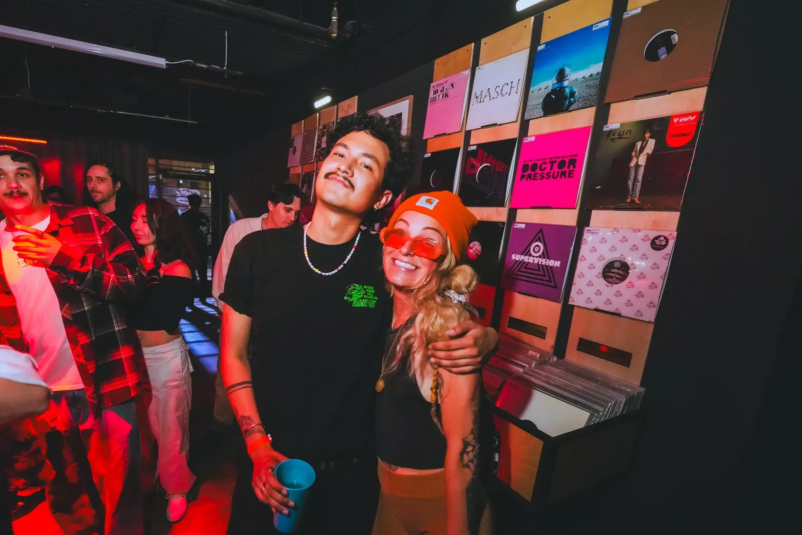 Two people on the dance floor in front of the record wall