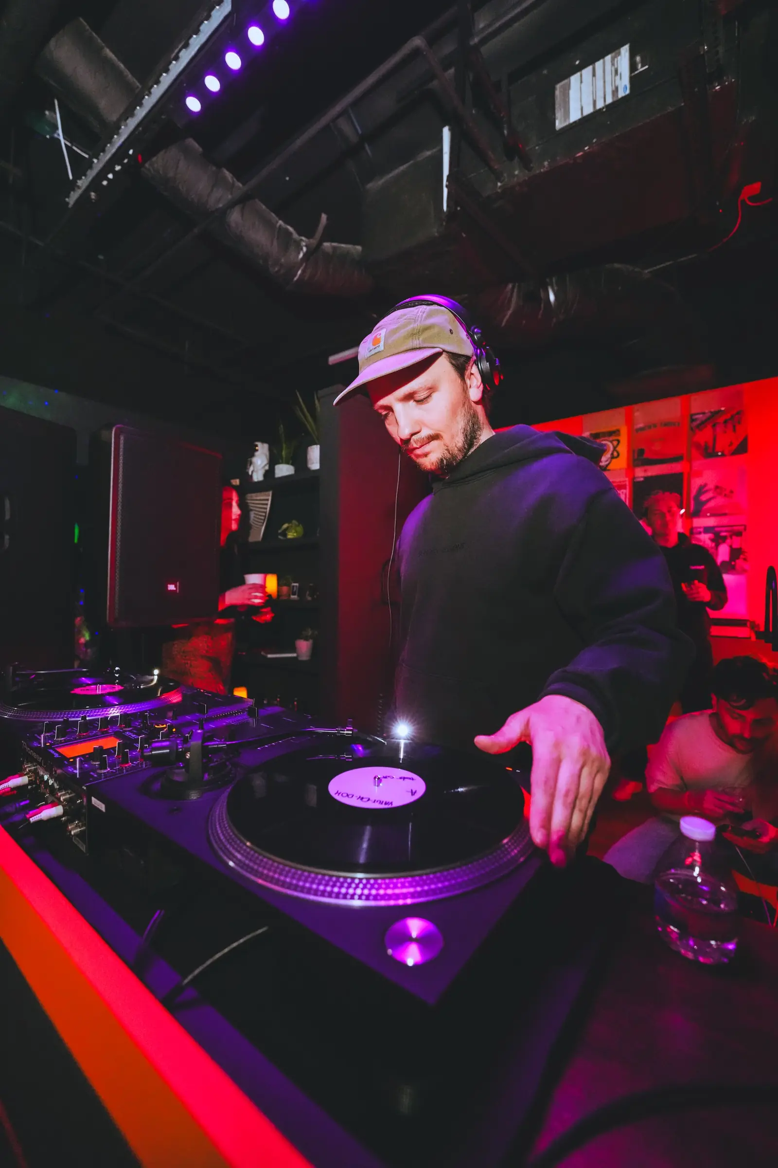Selector working the turntables under red light